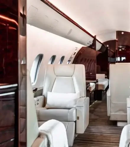 Luxurious private jet cabin interior with cream leather seats and rich wood finishes for holiday travel