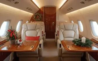 Luxurious private jet cabin decorated with festive Christmas garlands and holiday arrangements for 2025