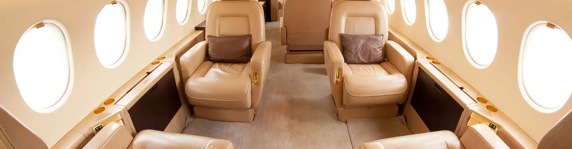 Spacious private jet cabin interior with cream leather seats arranged for comfortable business travel