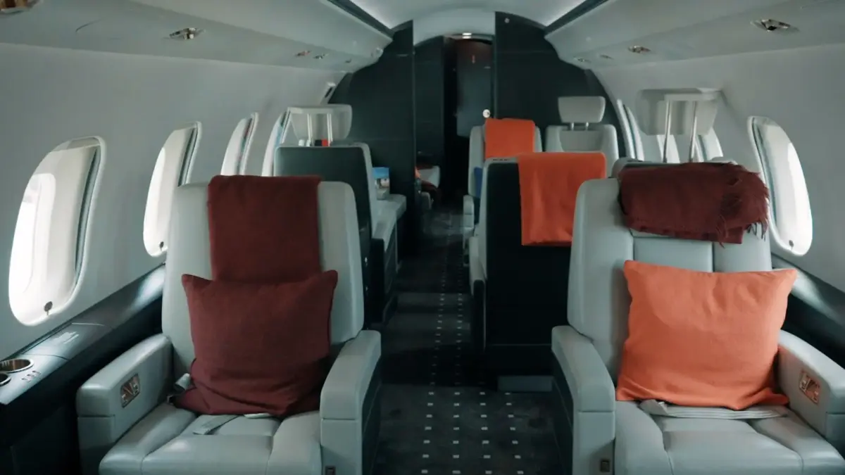 Luxurious private jet cabin interior featuring premium leather seating with colorful accent pillows and elegant design details
