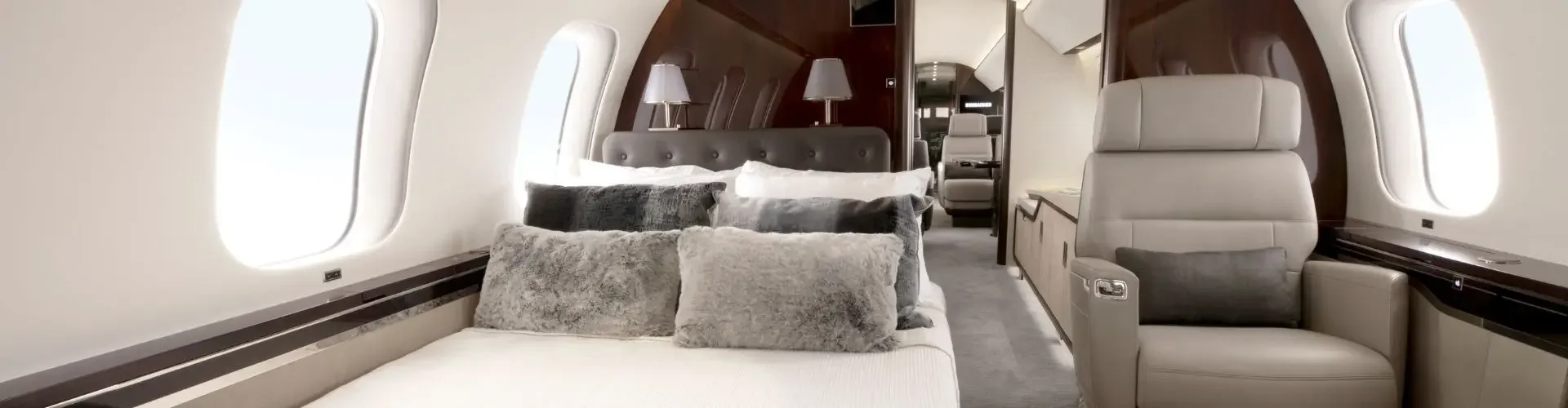Luxurious private jet cabin interior featuring plush seating, elegant bedding, and panoramic windows