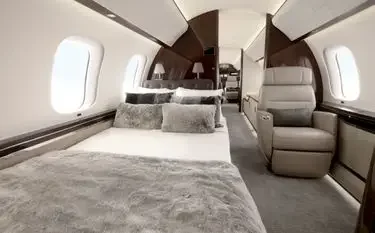Luxurious private jet cabin interior featuring plush seating, elegant bedding, and panoramic windows