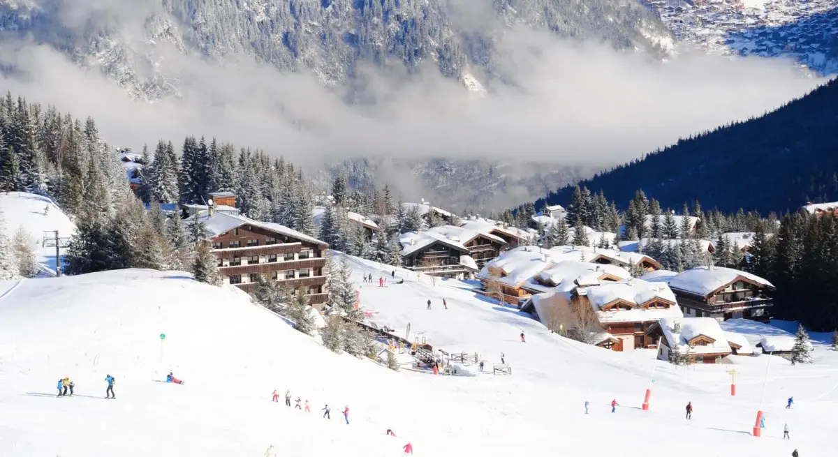 Luxury Alpine ski resort village nestled in snow-covered mountains with skiers enjoying pristine slopes