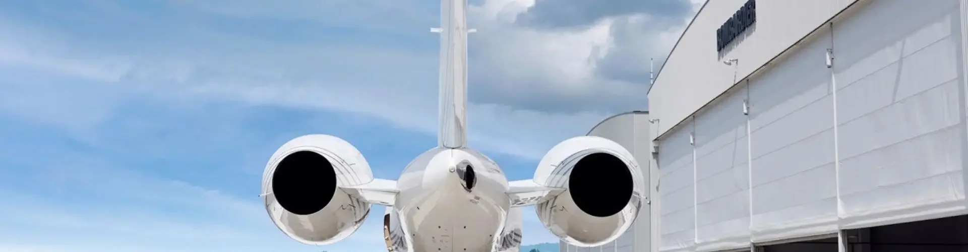 White private jet positioned at modern hangar ready for luxury charter flight departure