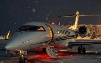 Luxury private jet parked on snowy tarmac at night, ready for winter ski resort destinations