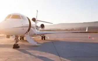 Luxury private jet parked on tarmac at sunset, showcasing premium charter aircraft for US travel