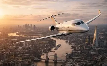 How Much is a 2 Hour Private Jet in the UK? Luxury private jet soaring above London cityscape at golden hour with Thames River and Tower Bridge visible