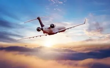 Luxury private jet soaring through golden sunset clouds above Asia for premium business travel