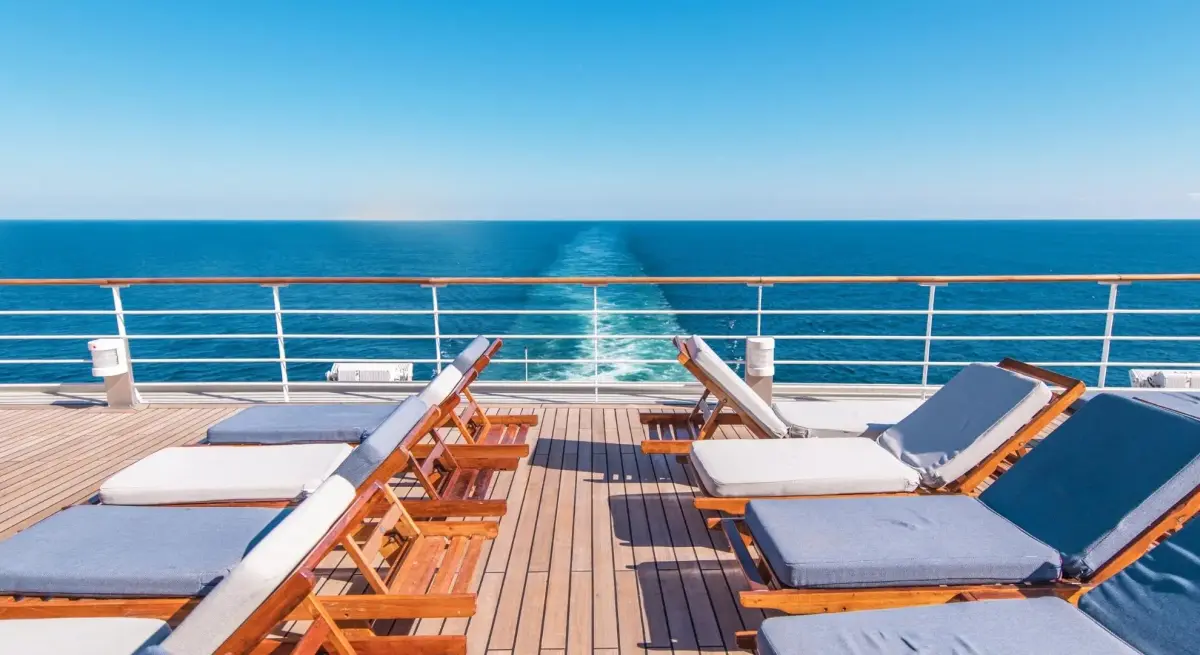 Luxury yacht deck with teak loungers overlooking azure Mediterranean waters near Monaco coastline