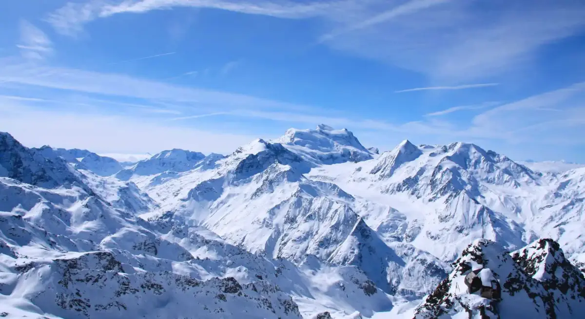 Majestic snow-covered Alpine peaks under brilliant blue skies showcasing premier winter destinations for luxury private jet travel