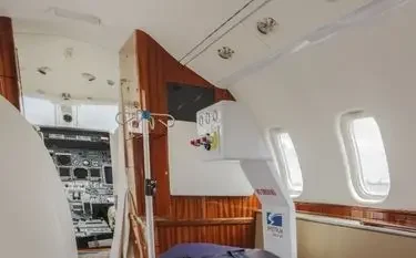 What Is an Air Ambulance and How Does It Work in the US? Medical equipment and stretcher inside air ambulance aircraft cabin with cockpit visible through doorway