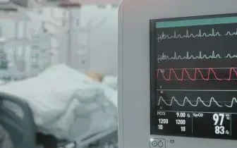 Medical monitoring equipment displaying vital signs next to patient bed in air ambulance cabin