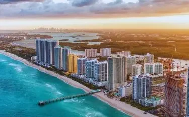 Private Jet Charters from Miami-Opa Locka Executive Airport (OPF) Miami Beach skyline with luxury high-rise buildings along turquoise coastline at golden sunset
