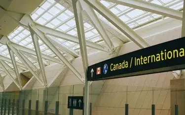 Private Jet from Toronto Pearson Airport to Los Angeles Modern airport terminal with glass ceiling and Canada International departure gate signage