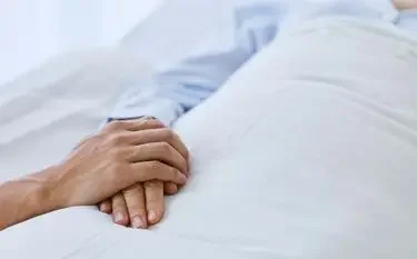 UK Bed-to-Bed Transfer Explained Peaceful hands resting on crisp white bedding symbolizing comfortable bed-to-bed transfer service