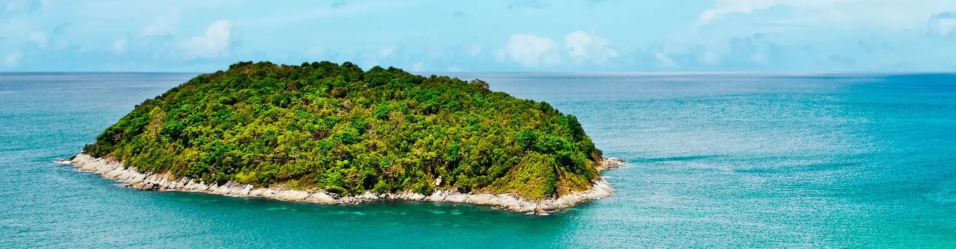Private jet approaching tropical island paradise with turquoise waters and lush green coastline