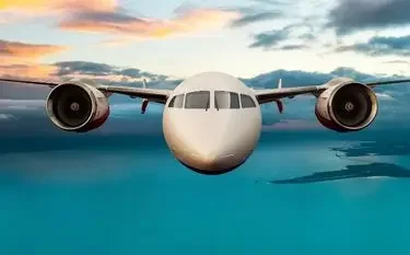 Private jet flying above turquoise waters at sunset showcasing luxury travel and exclusive aviation benefits