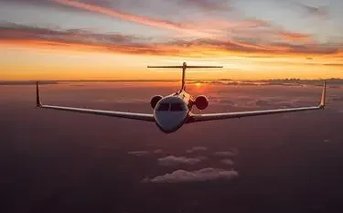 The Ultimate Guide to Private Jet Charter Services in the UK Private jet flying above clouds during golden sunset showcasing luxury charter flight experience