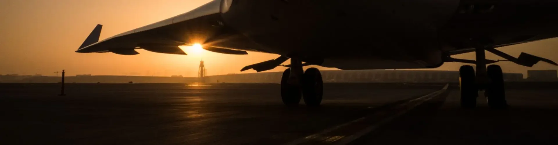 Private Jet vs Commercial Airlines: Which One is Right for You? Private jet silhouetted against golden sunset on tarmac, showcasing luxury travel advantages over commercial flights