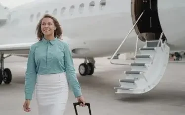Professional woman with luggage walking confidently toward luxury private jet on Canadian tarmac