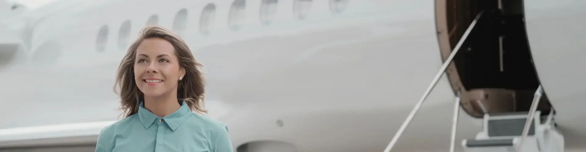 Professional woman with luggage walking confidently toward luxury private jet on Canadian tarmac