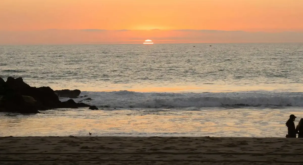 Serene ocean sunset with golden sky and gentle waves, representing peaceful winter escape destinations accessible by private jet