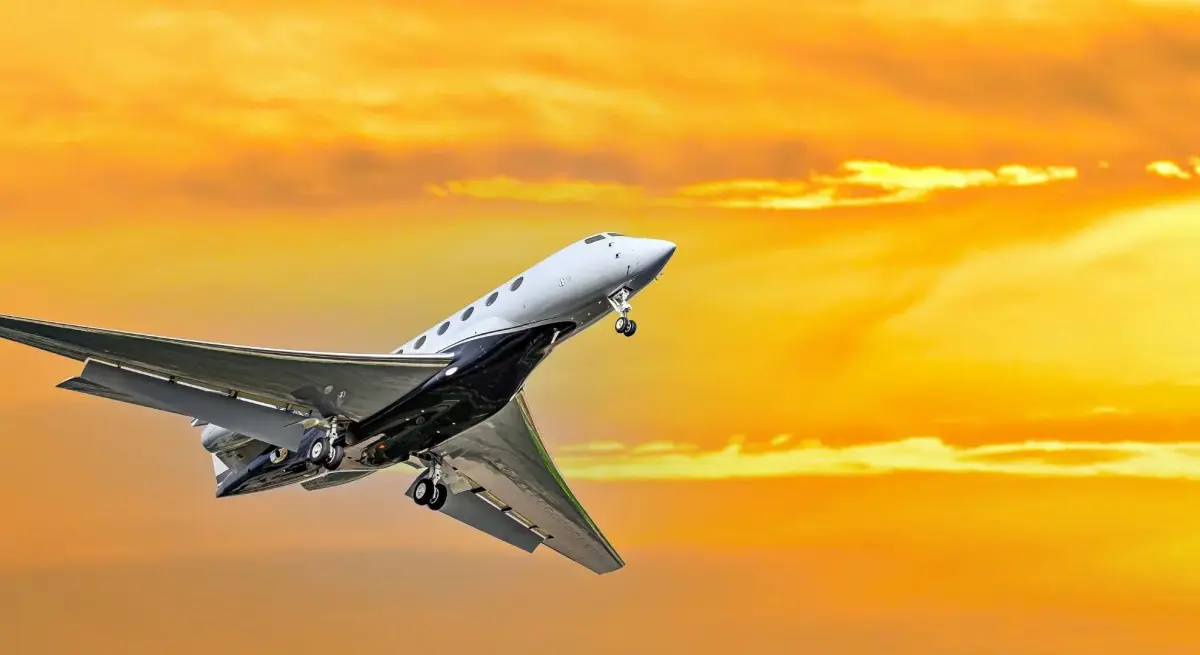 Sleek private jet ascending through golden sunset sky showcasing luxury charter flight experience