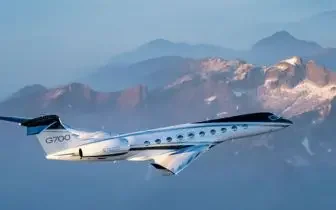 Sleek private jet soaring above snow-capped mountain peaks during golden hour flight