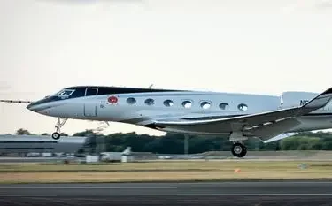 Private Jet from London RAF Northolt to Amsterdam Sleek silver turboprop aircraft landing on runway, showcasing premium aviation for London to Amsterdam routes