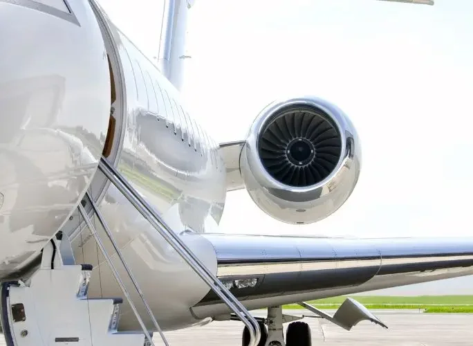 Sleek white private jet engine and fuselage detail showcasing premium aviation engineering and luxury travel craftsmanship