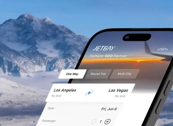 Smartphone displaying Jetbay private jet booking app interface with snow-capped mountains in background
