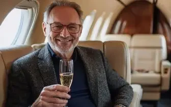 Sophisticated businessman enjoying champagne aboard luxury private jet cabin in Canada