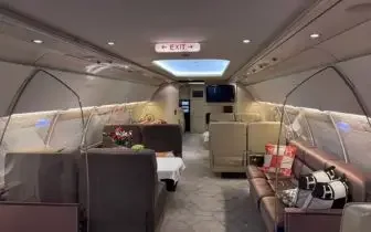 Spacious private jet cabin interior with executive seating and conference table for business travel