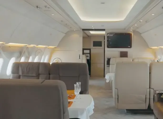 Spacious private jet cabin interior with luxury leather seating and elegant dining setup for executive travel