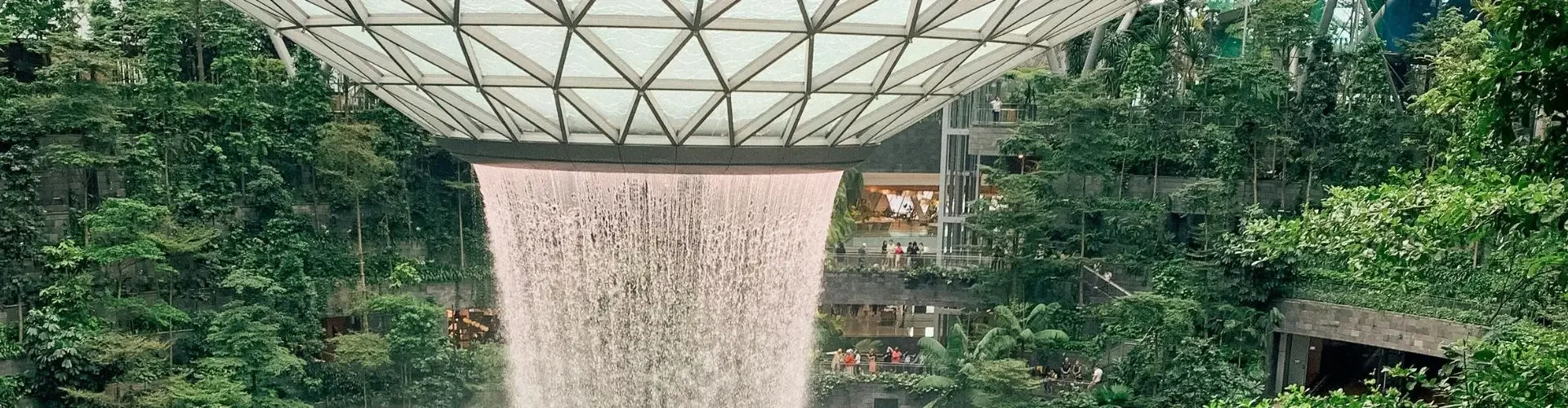 Can Private Jets Land at Changi Airport? Indoor waterfall cascades through geometric ceiling as train passes through Singapore Changi Airport terminal