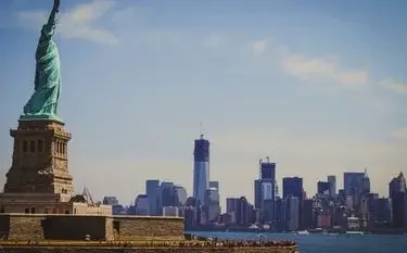 Statue of Liberty overlooking Manhattan skyline from harbor, showcasing New York's iconic landmarks for private jet travelers