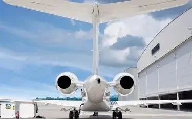 White private jet positioned at modern hangar ready for luxury charter flight departure