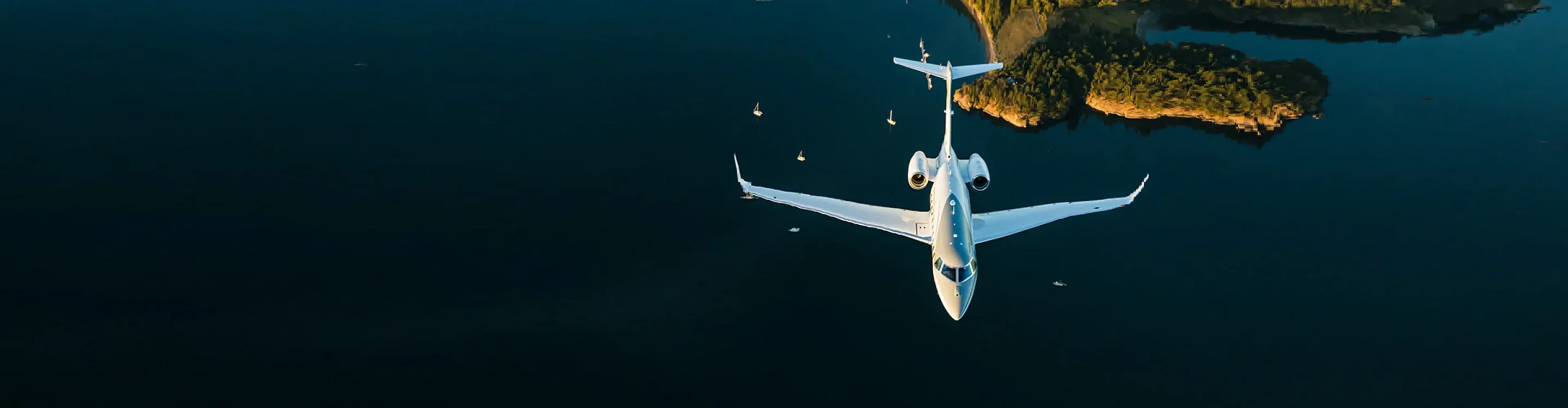 White private jet soaring above turquoise Mediterranean waters near golden coastal cliffs and anchored yachts