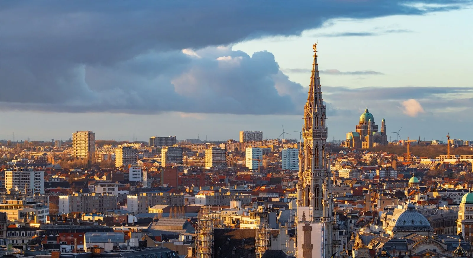 Brussels cityscape with Gothic spire and historic architecture bathed in golden light for luxury jet travel