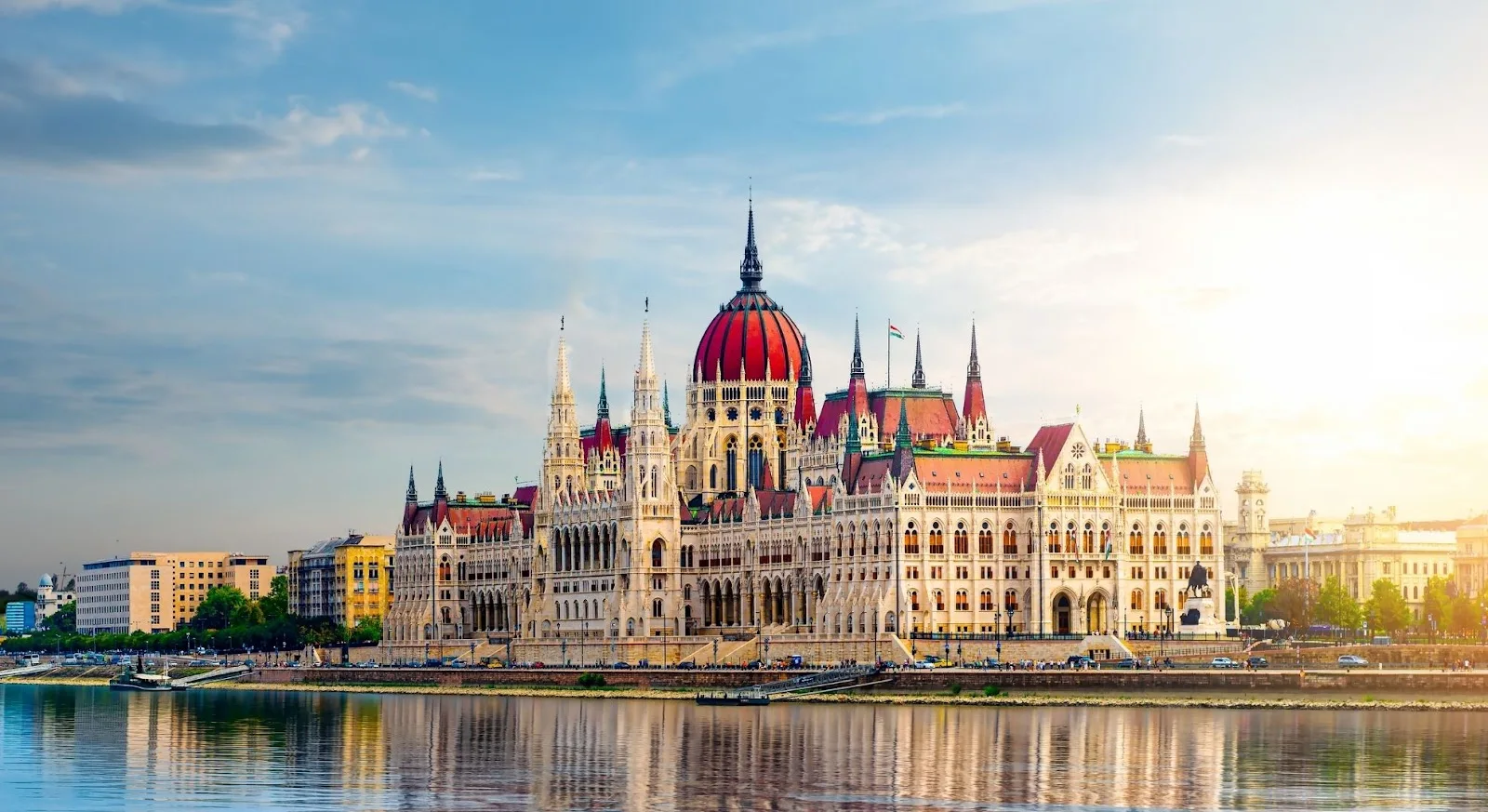 Hungarian Parliament Building with distinctive red dome reflecting in Danube River waters in Budapest