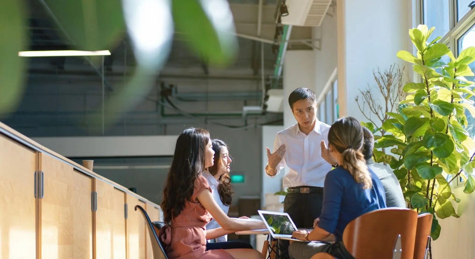 Business professionals discussing empty leg flight options in modern office setting with natural lighting