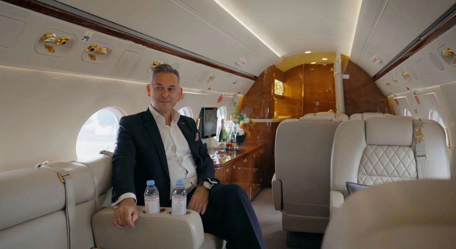 Business traveler relaxing in luxurious private jet cabin with leather seating and premium amenities