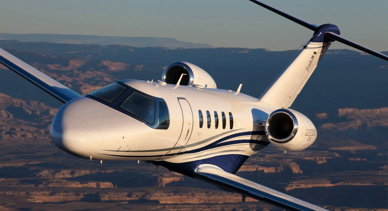 Cessna Citation CJ4 private jet flying over canyon landscape