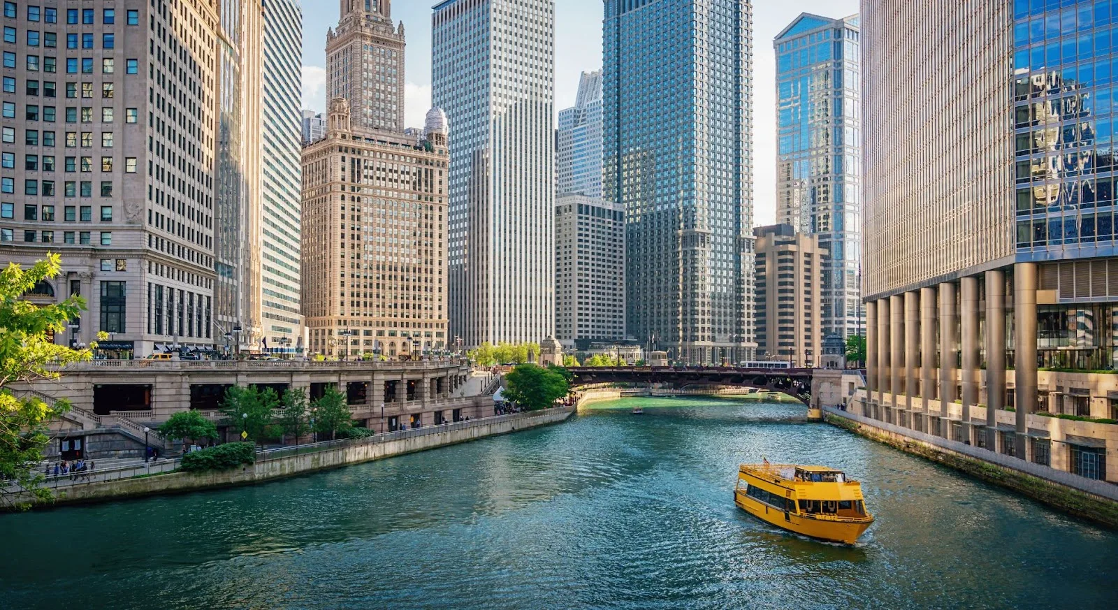 Chicago River flowing through downtown financial district with towering skyscrapers and tour boat