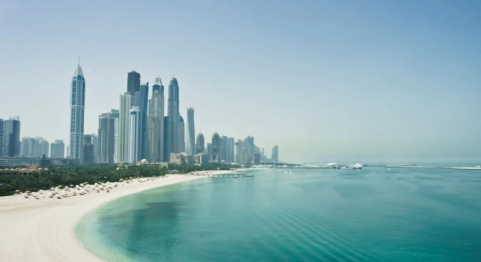 Dubai Marina skyline with pristine beach and turquoise waters showcasing luxury travel destination for private jet charters