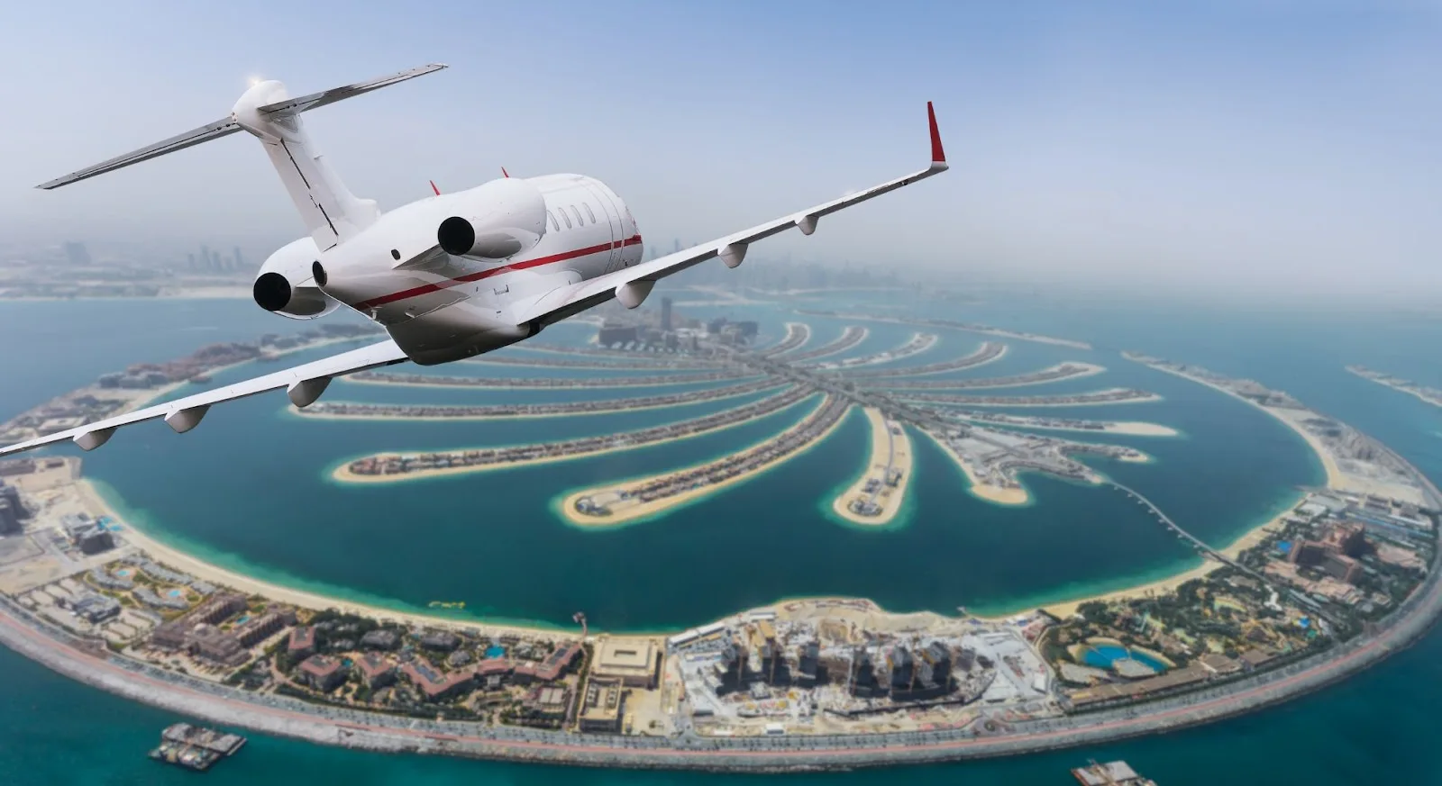 Private jet flying over Palm Jumeirah island and Dubai coastline in the United Arab Emirates
