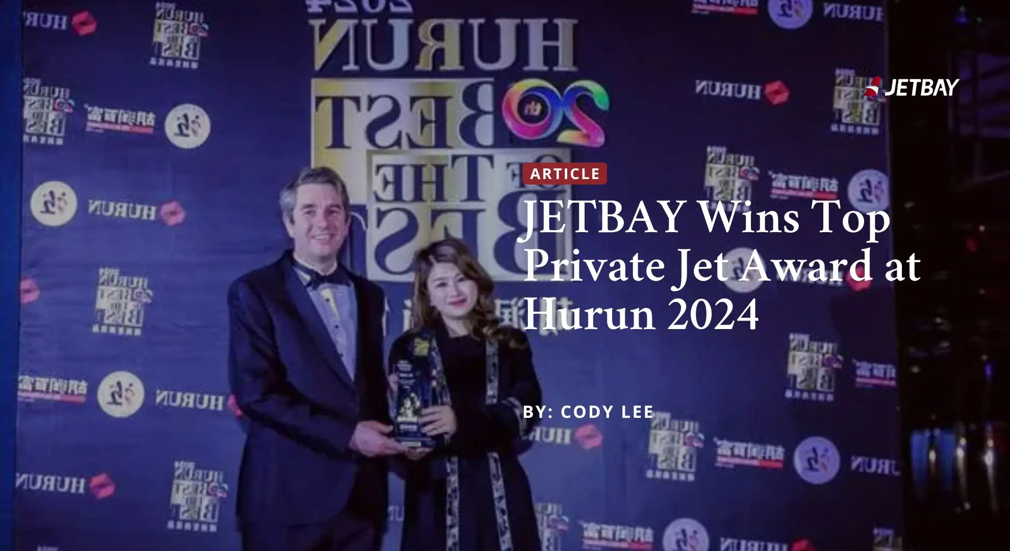 JETBAY executives celebrating with crystal trophy at Hurun Best of the Best private aviation awards ceremony