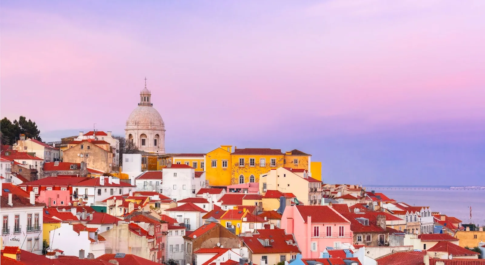Lisbon Alfama district skyline with National Pantheon dome and colourful historic houses overlooking the Tagus River in Portugal