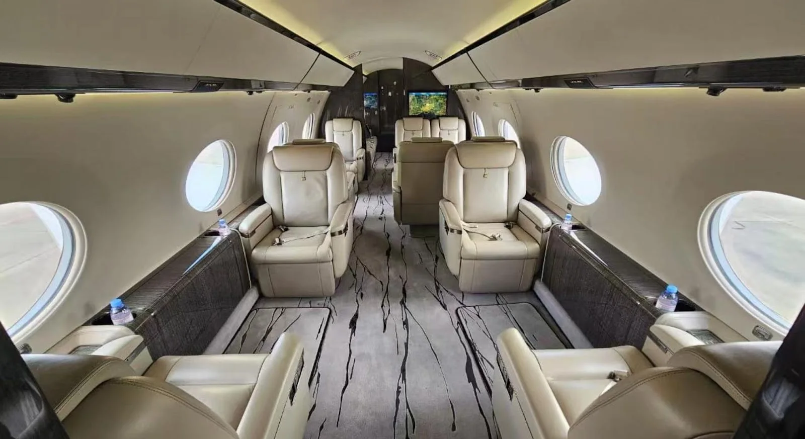 Luxurious private jet cabin interior featuring cream leather seats and marble flooring for Hong Kong to NYC travel