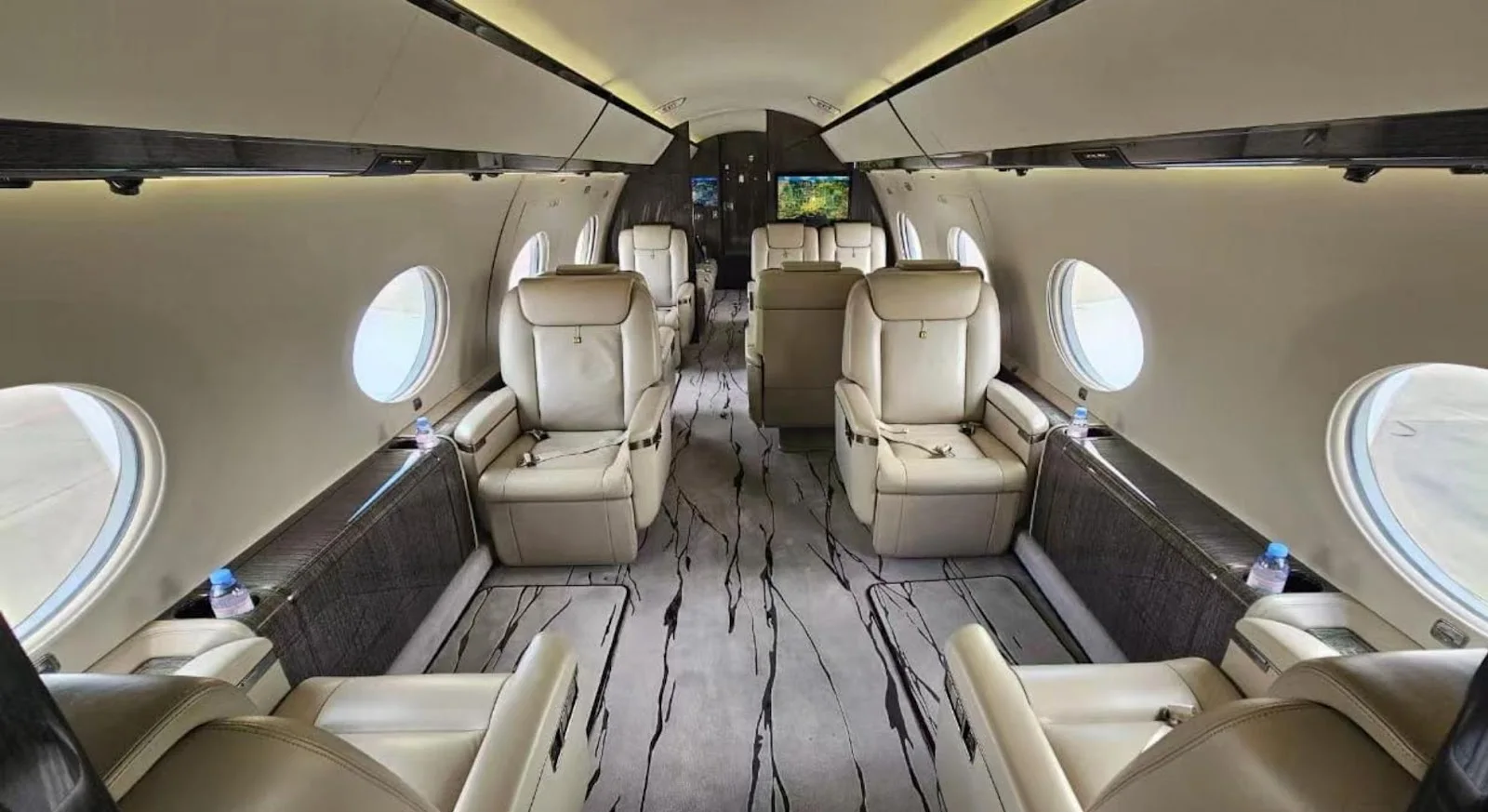 Luxurious private jet cabin interior with cream leather seats and marble flooring for Bangkok to Hong Kong flights